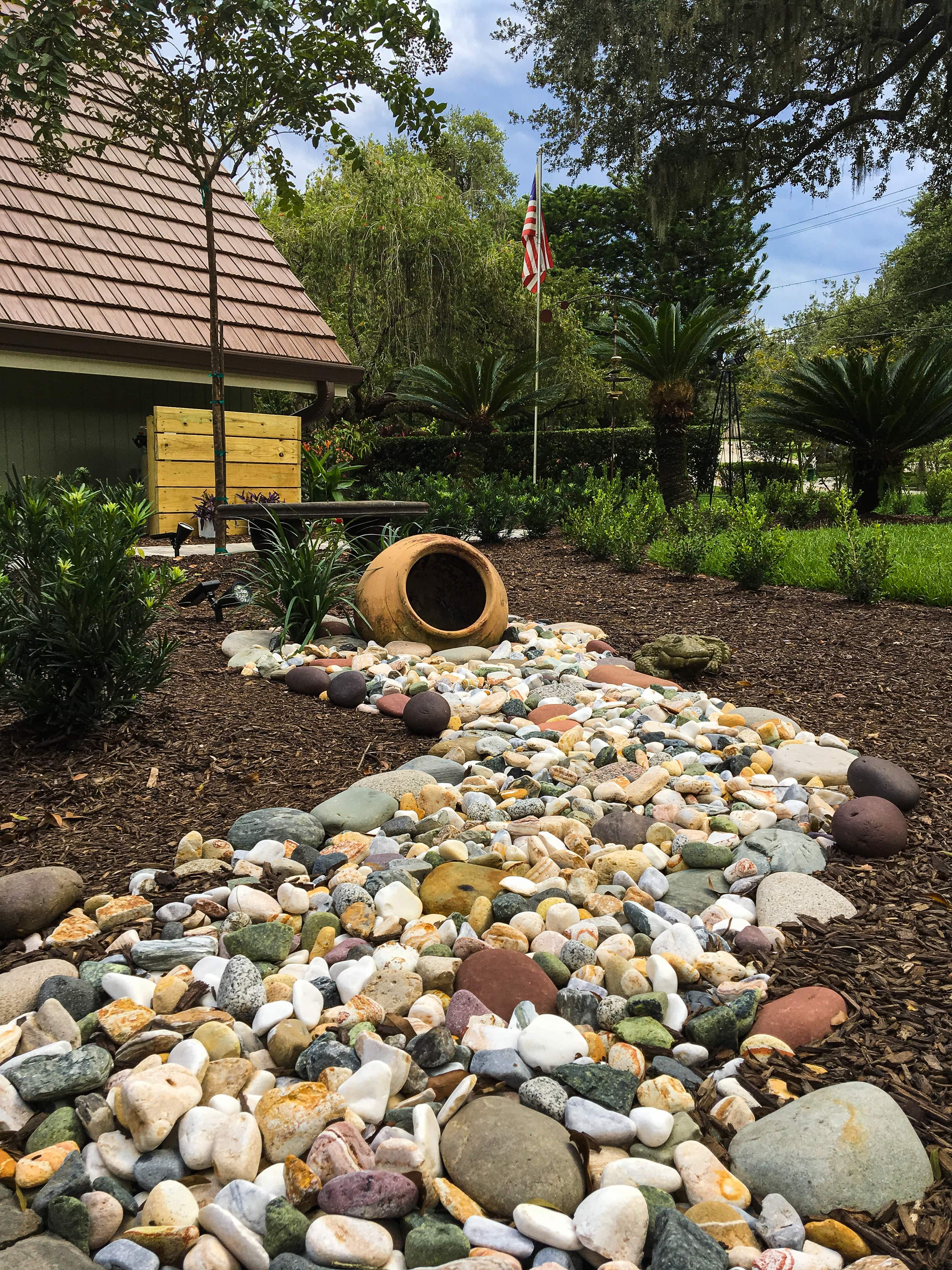 large water feature with pot and natural rock stream and flower bed